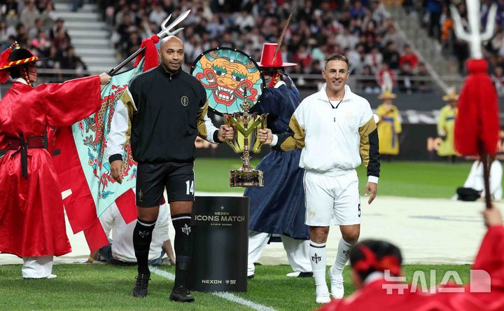 20일 오후 서울 마포구 서울월드컵경기장에서 열린 '2024 넥슨 아이콘매치' FC스피어(공격수팀)와 실드 유나이티드(수비수팀)의 경기, FC스피어 앙리 감독과 실드 유나이티드 칸나바로 감독이 트로피를 맞잡고 있다. 2024.10.20. / 사진 = 뉴시스