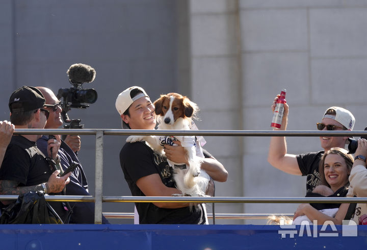 [로스앤젤레스=AP/뉴시스] LA 다저스의 오타니 쇼헤이가 1일(현지시각) 미 캘리포니아주 로스앤젤레스에서 열린 2024 월드시리즈(WS) 우승 기념 퍼레이드에서 반려견 디코이(일본명 데코핀)를 안고 있다. 다저스는 WS에서 뉴욕 양키스에 4승1패를 거두고 통산 8번째 정상에 올랐다 2024.11.02. / 사진 = 뉴시스