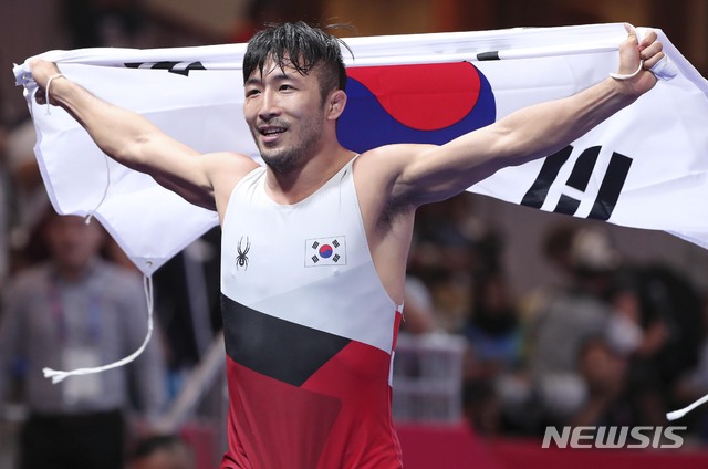 21일(현지시각) 오후 인도네시아 자카르타 컨벤션센터에서 열린 '2018 자카르타-팔렘방 아시아안게임' 레슬링 남자 그레코로만형 67kg급 금메달 결정전에서 한국 류한수가 금메달을 차지한 뒤 태극기를 들고 기뻐하고 있다. 2018.08.21. / 사진 = 뉴시스