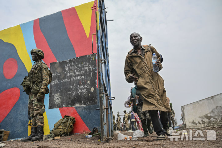 [고마=AP/뉴시스] 30일(현지 시간) 콩고민주공화국(DRC) 고마에서 M23 반군에 항복한 정부군과 경찰(오른쪽)이 장소가 알려지지 않은 곳으로 호송되면서 트럭에 탑승하고 있다. M23을 비롯한 콩고강연맹(AFC)의 지도자 코르네유 낭가는 기자회견을 통해 고마를 완전 점령했다고 주장한 후 DRC 정부와 대화할 용의가 있다고 발표했다. 2025.01.31. / 사진 = 뉴시스