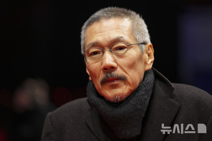 [베를린=AP/뉴시스] 홍상수 감독이 20일(현지 시간) 독일 베를린에서 열린 제75회 베를린 국제영화제에서 영화 ‘그 자연이 네게 뭐하고 하니' 레드 카펫 행사에 참석해 포토 타임을 갖고 있다. 임신 중인 김민희는 홍 감독과 베를린에 동행했으나, 공식 석상에는 서지 않았다. 2025.02.21. / 사진 = 뉴시스